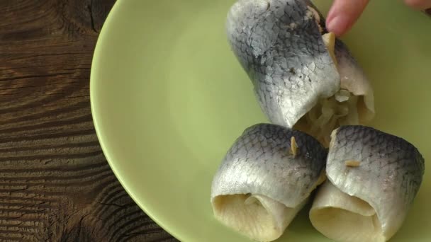 Fischbrötchen mit saurem Hering auf grünem Teller — Stockvideo