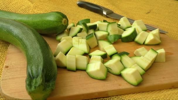 Gesneden courgette op een houten snijplank — Stockvideo