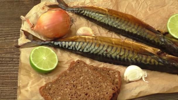 Whole smoked fish (mackerel) on a dark wooden table — Stock Video