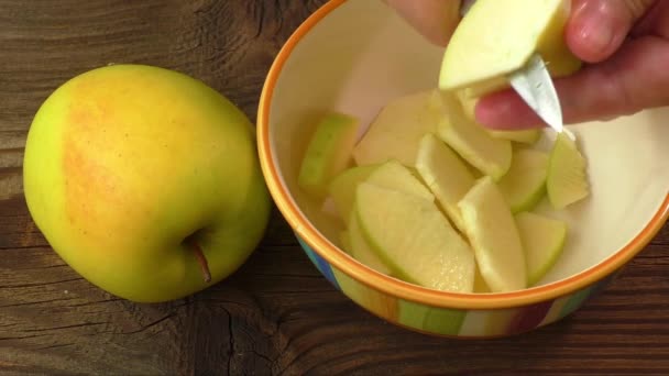 Nakrájíme na plátky jablek v misce pro jam na dřevěný stůl — Stock video