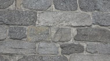 Taştan bir duvarın farklı boyutlarda taşları var..