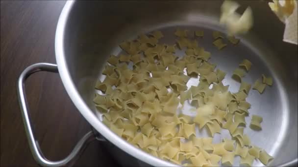 Добавление макарон в горшок — стоковое видео