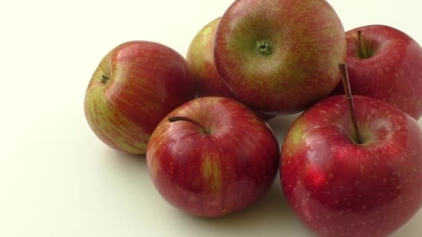 Vue rapprochée de quelques pommes rouges isolées sur fond blanc — Video