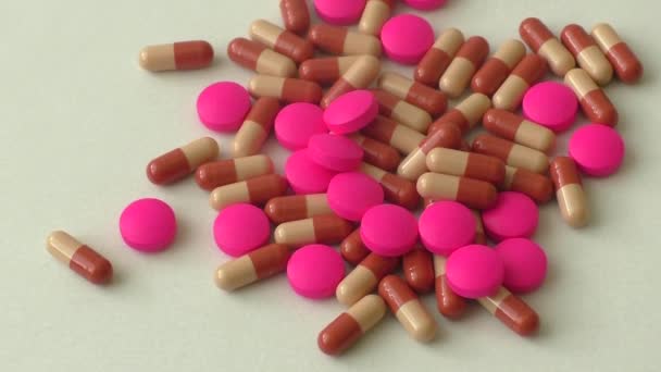 Haufen bunter Pillen auf weißem Hintergrund — Stockvideo