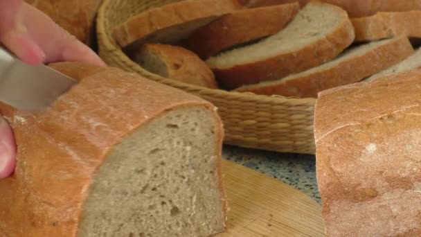 Cutting bread on wooden board — Stock Video