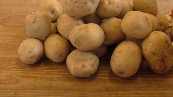 Fresh potatoes on rustic wooden background — Stock Video