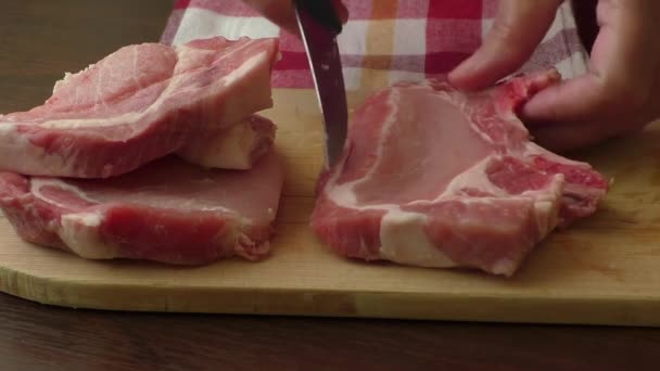 Steak de côtelette de porc cru sur fond en bois — Video