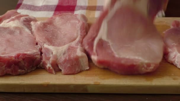 Raw pork chop steak on wooden background — Stock Video