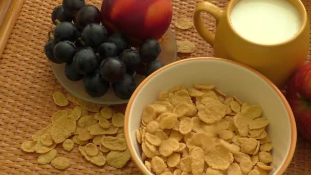 Cornflakes en melk vallen in een kom — Stockvideo