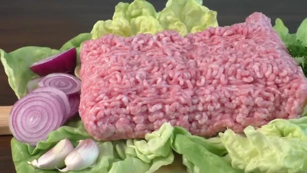 Raw minced meat with vegetables on wooden board — Stock Video