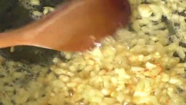 Лук жарится на сковороде — стоковое видео