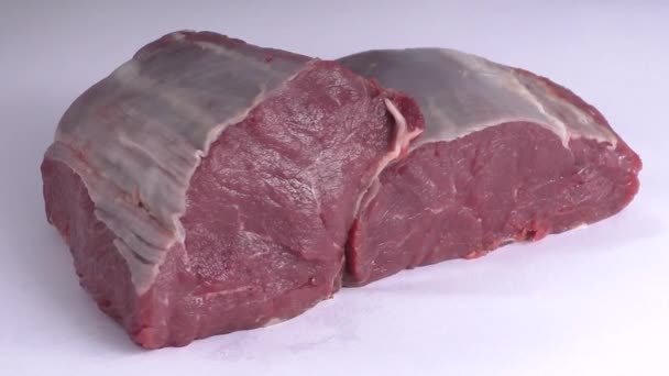 Свежее сырое мясо на белом фоне — стоковое видео