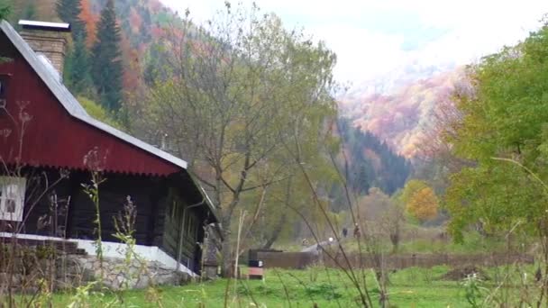 Cabanas ao longo da trilha em um vale cercado por montanhas — Vídeo de Stock