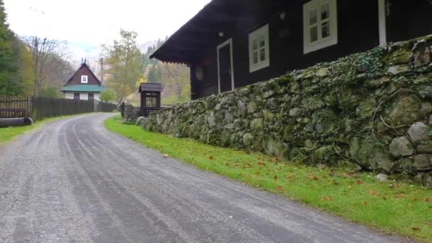 Cabañas a lo largo del sendero en un valle rodeado de montañas — Vídeos de Stock