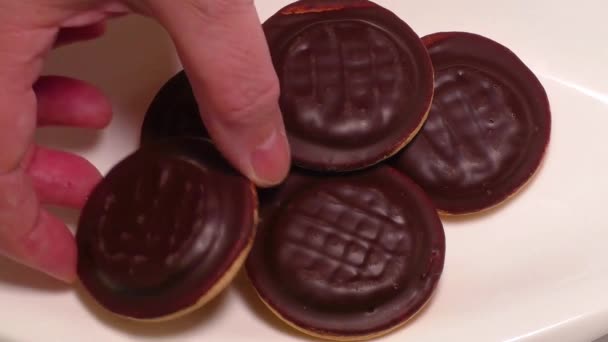 Печенье, покрытое шоколадом, на белой тарелке — стоковое видео