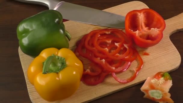 Styckning och förbereda paprika på en skärbräda, inklusive röd, gul och grön — Stockvideo