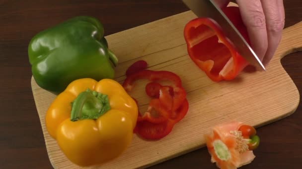 Резка и подготовка колбасных перцев на разделочной доске, включая красный, желтый и зеленый — стоковое видео