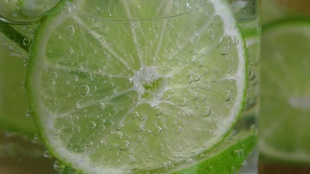 Glass with lime and sparkling water — Stock Video