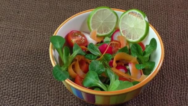Чаша свежего овощного салата на джутовой скатерти — стоковое видео