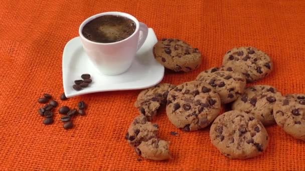 Chocolate chip cookies and cup of coffee shot on jute colored cloth — Stock Video