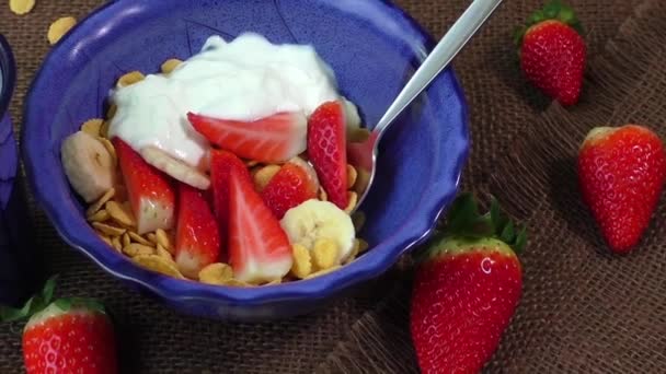 Gezond ontbijt. Cornflakes, melk, verse aardbeien en banaan — Stockvideo