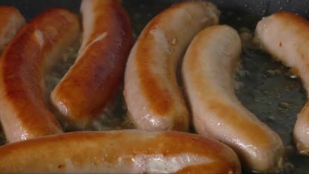 Sausages frying in a skillet — Stock Video