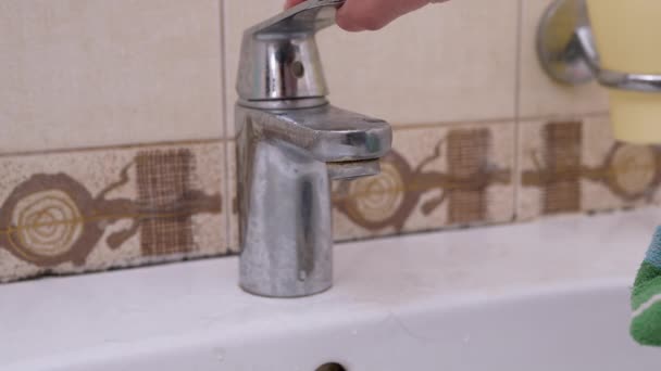 La mano femminile accende il rubinetto dell'acqua e lava lo spazzolino da denti in bagno — Video Stock