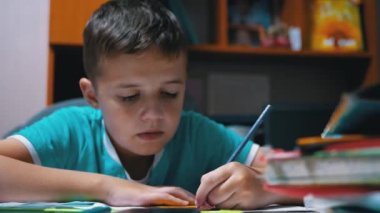 Çocuk evde renkli kalemlerle resim çiziyor. Ev Eğitimi, Eğitim Konsepti.