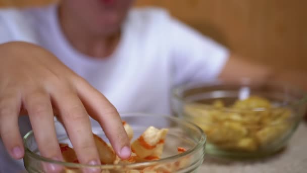 Kid Hand Toma Chips, Crackers from a Plate. Comer con alimentos de aperitivo perjudiciales — Vídeos de Stock