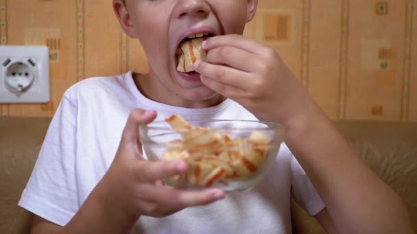 Honger Kind Hand Plaatst van de plaat Chips in Mouth. Jongen eet Fast Food — Stockvideo