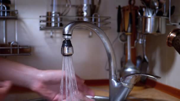 Männliche Hände unter einem starken Wasserstrahl waschen. Platsch. Wasser läuft aus dem Hahn — Stockvideo