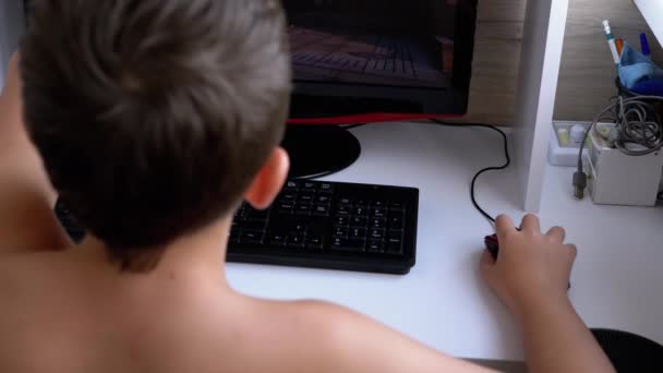 Tienerjongen Gamer zit in een fauteuil spelen van videospelletjes op de computer. Internet — Stockvideo