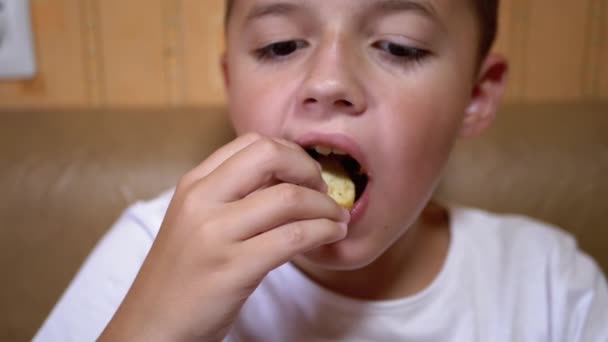 Hungriga kaukasiska Teen Puts Croutons i munnen med handen. Boy äter snabbmat. — Stockvideo