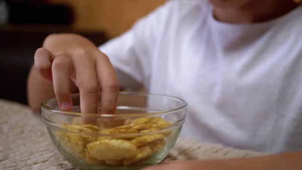 Kid Hand nimmt Cracker von einem Teller. Schädliche Snacks essen. Fast Food — Stockvideo