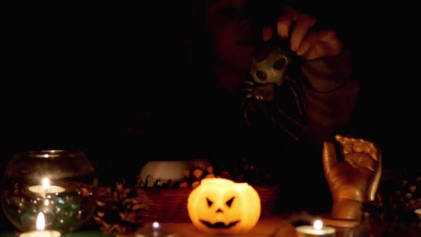 Záhadný chlapec s v kapuci hraje s pavoukem od svíčky v tmavém pokoji na Halloween — Stock video