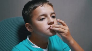 Gülümseyen çocuk TV izliyor patates cipsi yiyor. Yüzünde sürpriz ve sevinç