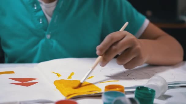 हैंड पेंट्स में ब्रश के साथ बच्चे कागज की सफेद शीट पर पीला पेंट के साथ सूर्य — स्टॉक वीडियो