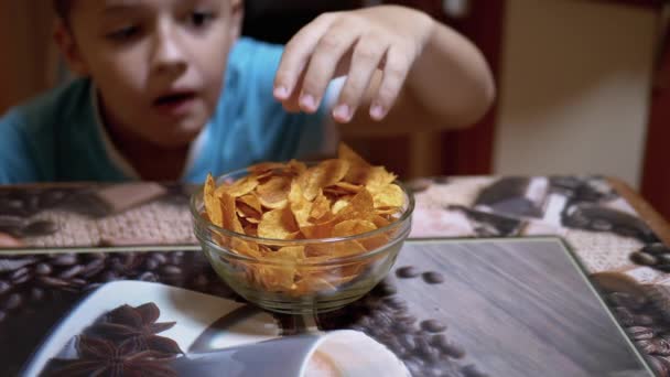 Adolescente com fome rouba batatas fritas da mesa em uma placa enquanto ninguém vê — Vídeo de Stock