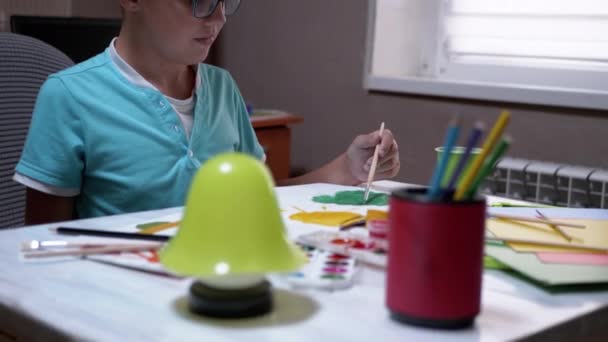 Child with a Brush in Hand Paints Tree with Green Paint on White Sheet of Paper — Stock Video