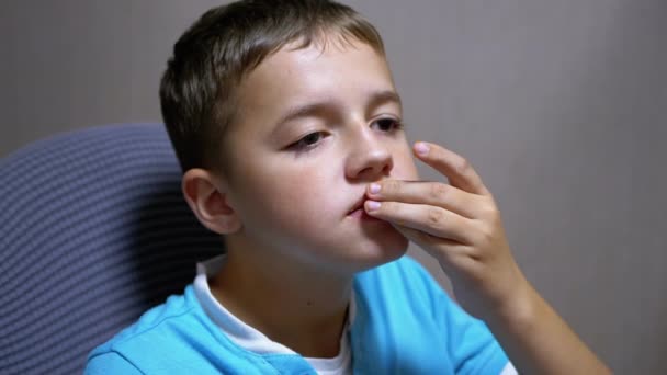 Niño sonriente viendo televisión comiendo patatas fritas. Sorpresa y deleite en su rostro — Vídeos de Stock