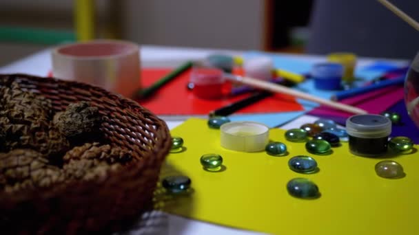 En la tabla se disponen aleatoriamente Avocarel Pinturas, Lápices, Cepillos, Papel de colores — Vídeo de stock