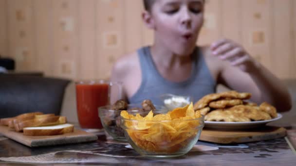 Hambriento niño mano toma crujiente de oro patatas fritas de la placa. Comida chatarra en la cena — Vídeos de Stock