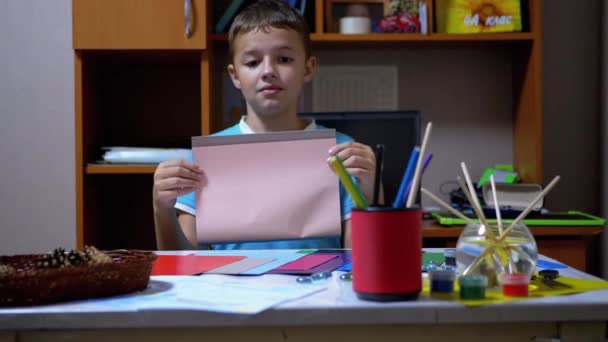 Mavi Tişörtlü Ciddi Çocuk, Renkli Kağıt 'ta Açık Pembeyi Gösteriyor — Stok video