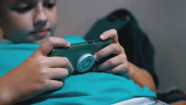 Smiling Boy Sit speelt een mobiele game op de smartphone thuis in Relaxed State — Stockvideo