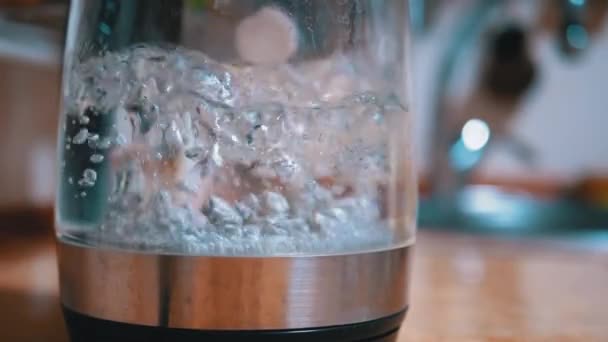 Burbujas en agua hirviendo dentro de vidrio Hervidor eléctrico en cocina de fondo — Vídeos de Stock