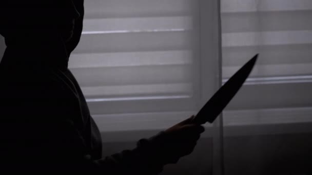 Silhouette of Lonely Child in Hood with Knife in Hand near Window. Killer Teen — Stock Video