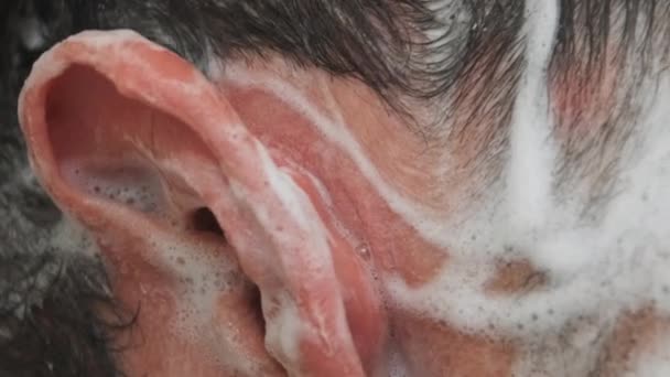 Europäischer Mann wäscht Haarshampoo im Badezimmer. Haarpflege. Nahaufnahme. Seitenansicht — Stockvideo