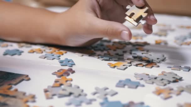 Gyerekek Kezek Gyűjtse Puzzle az asztalon. Gyermekfejlesztési koncepció. Közelkép — Stock videók