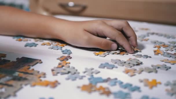Le mani dei bambini raccolgono Puzzle sul tavolo. Concetto di sviluppo infantile. Primo piano — Video Stock