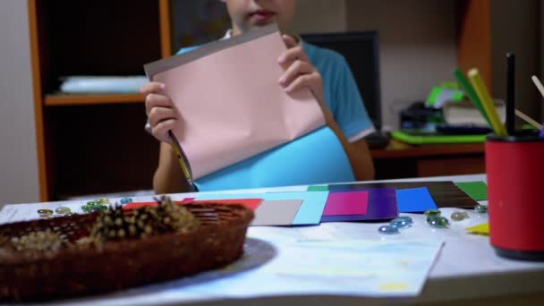Niño serio con camiseta azul levanta las manos y muestra rojo en papel de colores — Vídeo de stock